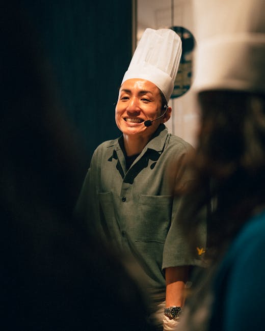 A chef smiling and taking notes during a cooking demonstration
