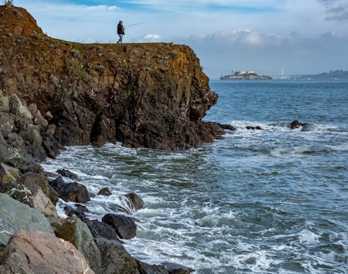 Person on Cliff on Sea Shore