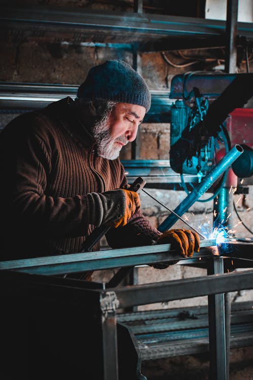 A Man Welding in a Workshop 