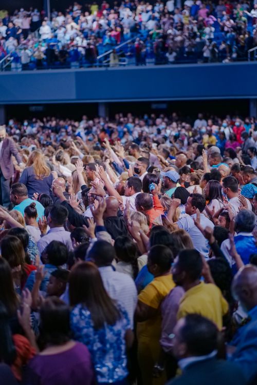 Free Energetic crowd at a packed concert, enjoying live music in a vibrant outdoor setting. Stock Photo