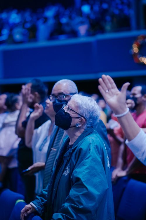 Free Elderly people wearing masks enjoying a live concert indoors, showcasing safety and enjoyment. Stock Photo