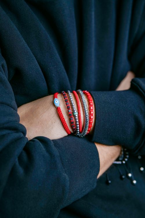 Free Close-up of a person wearing multiple bracelets with crossed arms, showcasing unique fashion style. Stock Photo