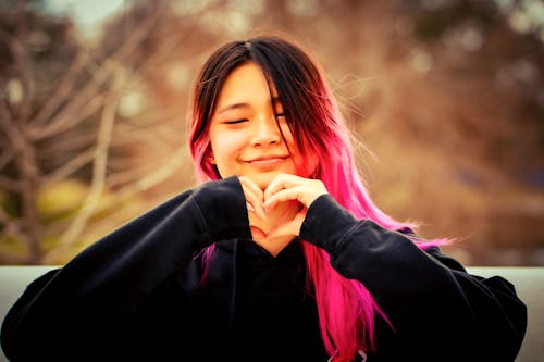A Girl with Pink Hair Making a Heart Shape with Her Hands 