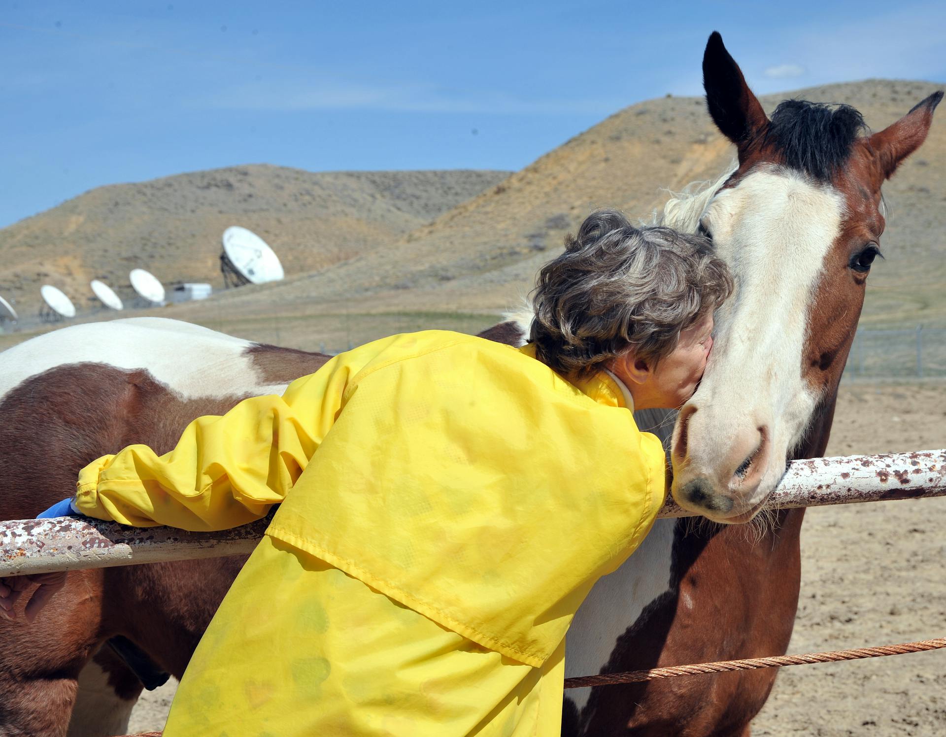Female kissing her horse on the ranch.