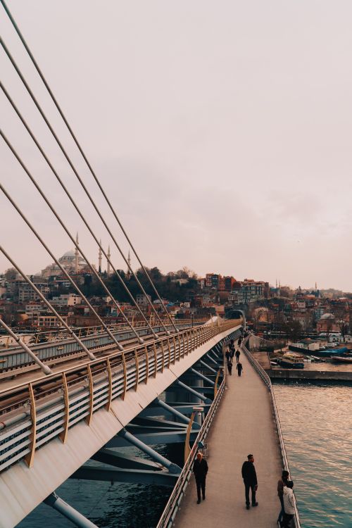 Free Aerial view of a bustling pedestrian bridge with cityscape background during sunset, creating a serene atmosphere. Stock Photo