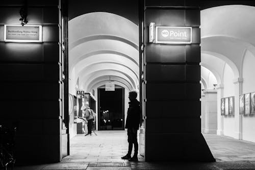 Silhouette of Man Standing at Station Entrance at Night