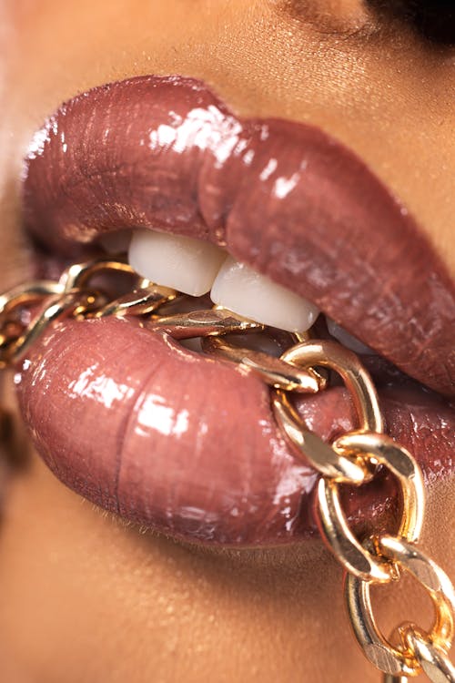 Close-up of Golden Chain in Woman Mouth