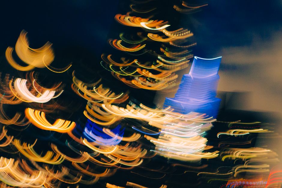 Dynamic abstract photo capturing colorful city lights at night with motion blur effect.