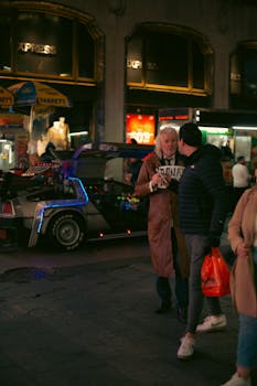 Vibrant city street at night with people and neon lights in an urban setting.