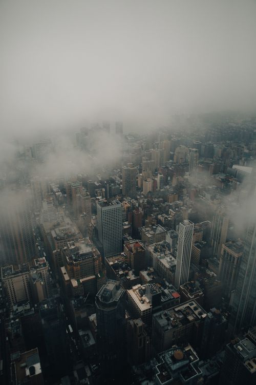 Free A striking aerial photograph of Manhattan, shrouded in clouds, with a moody and dramatic ambiance. Stock Photo