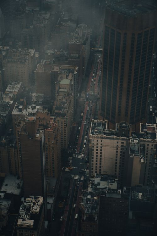 Free A dramatic aerial view capturing a city's skyscrapers enveloped in fog, creating a moody atmosphere. Stock Photo