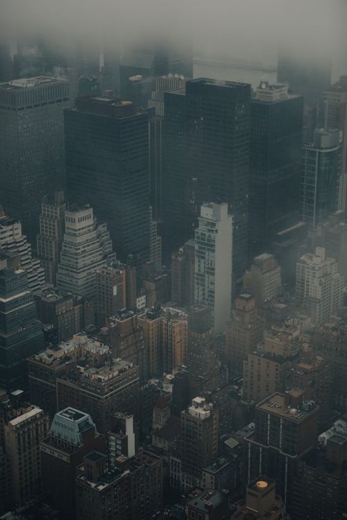 Free Aerial view of skyscrapers shrouded in fog, showcasing urban architecture in a modern cityscape. Stock Photo