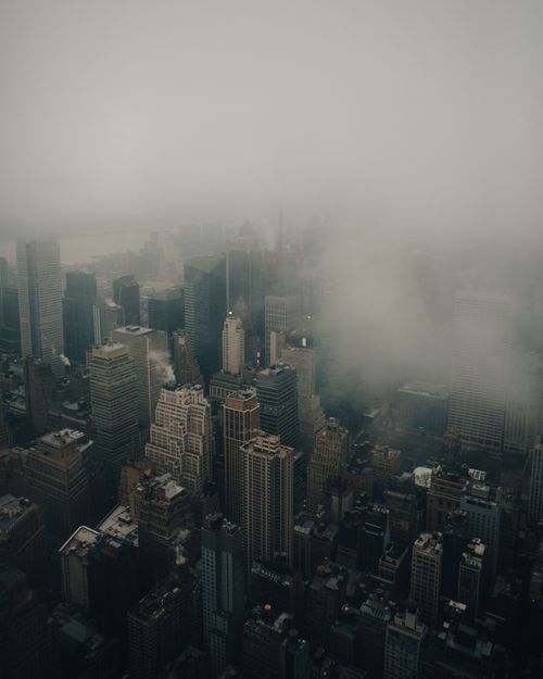Free Aerial view of a fog-covered cityscape with tall buildings and muted tones. Stock Photo