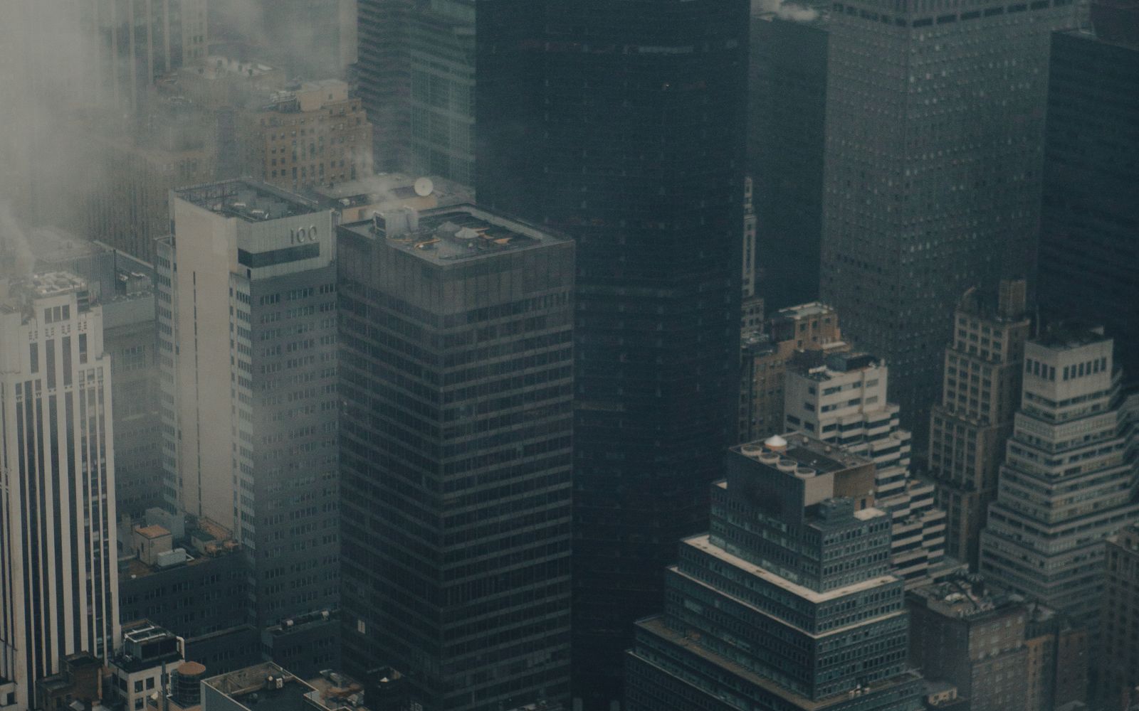 New York City skyline shrouded in fog and smog, with skyscrapers barely visible through the haze