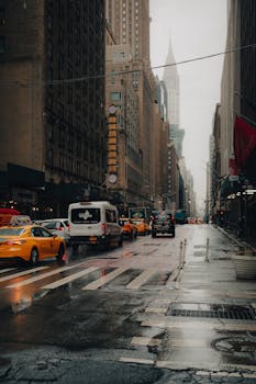 A rainy day in New York City with taxis and traffic on a busy street, showcasing the urban atmosphere.