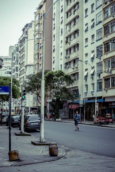 City street view with tall buildings and a pedestrian crossing during the day.