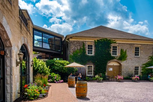 A picturesque ivy-covered building in a sunlit courtyard with outdoor seating in Spring Green, WI.