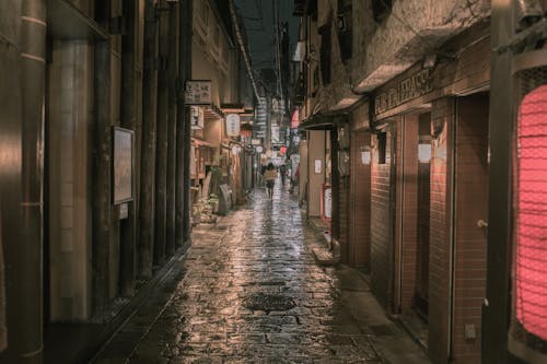 Person Walking on Concrete Alleyway at Night T