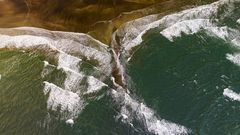Aerial view of swell lines approaching a coast at an angle