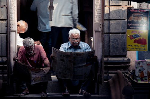 Two Men Reading Newspaper