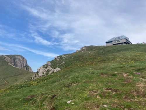 Free Tranquil mountain landscape featuring a hillside building under a bright sky. Stock Photo