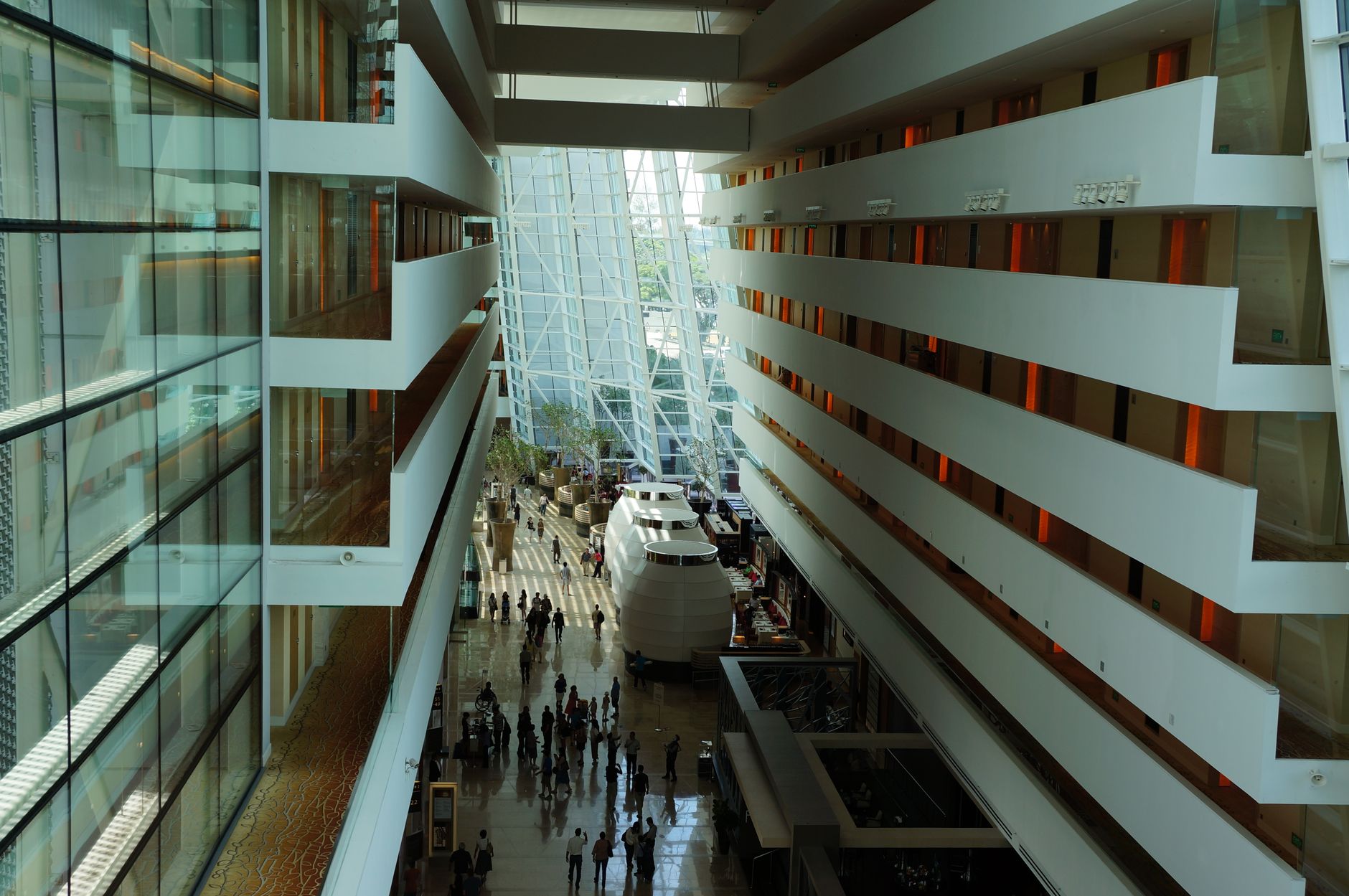 A bright, spacious modern hospital lobby with international flags displayed, symbolizing global patient care.