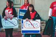 一群成年人在西弗吉尼亚州惠灵的街道上举着反弗恩斯标志进行抗议