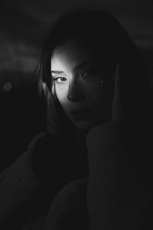 Portrait of a Beautiful Woman Sitting in a Dark Room