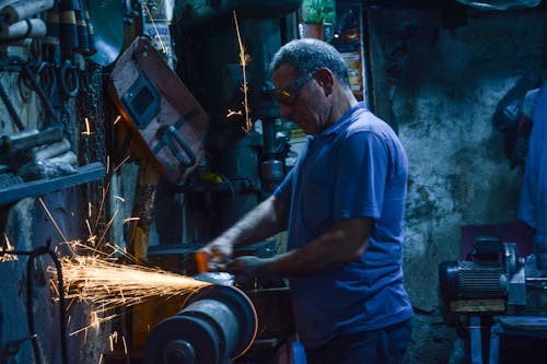 Metal Worker using a Grinder in the Workshop