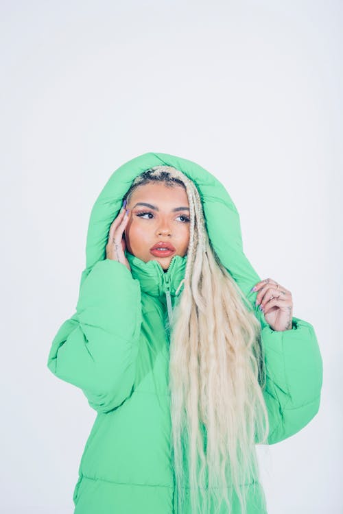 Studio Portrait of a Long-Haired Blonde Wearing a Green Hooded Jacket