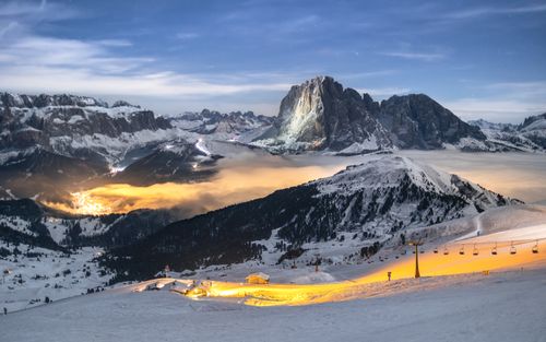 Free Breathtaking view of snow-covered Alps under starry night sky with illuminated village. Stock Photo