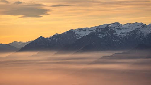View of Snowcapped Mountains under a Sunset Sky