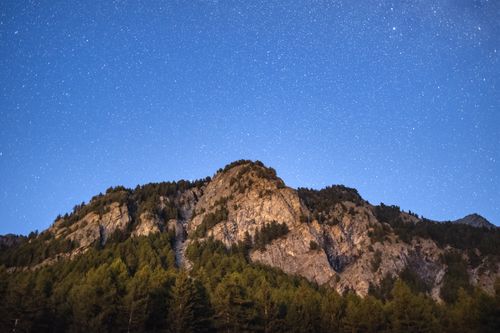 Free Scenic night view of rocky mountains under a star-filled sky with clear visibility. Stock Photo
