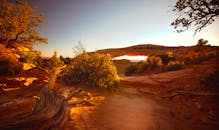 金色的日落映照在崎岖的天然沙漠拱门上，色彩鲜艳