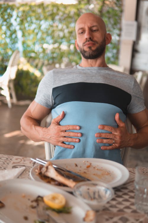 Free Man with hands on his abdomen suffering after eating too much Stock Photo