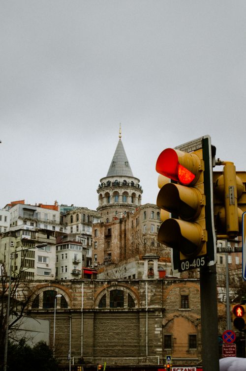 Free View of Galata Tower with traffic light in foreground, Istanbul's urban landscape. Stock Photo