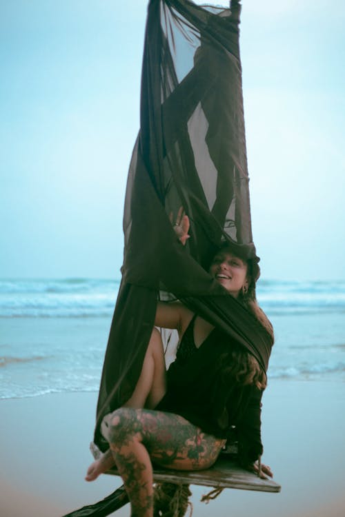 Woman Sitting with Net on Beach and Posing