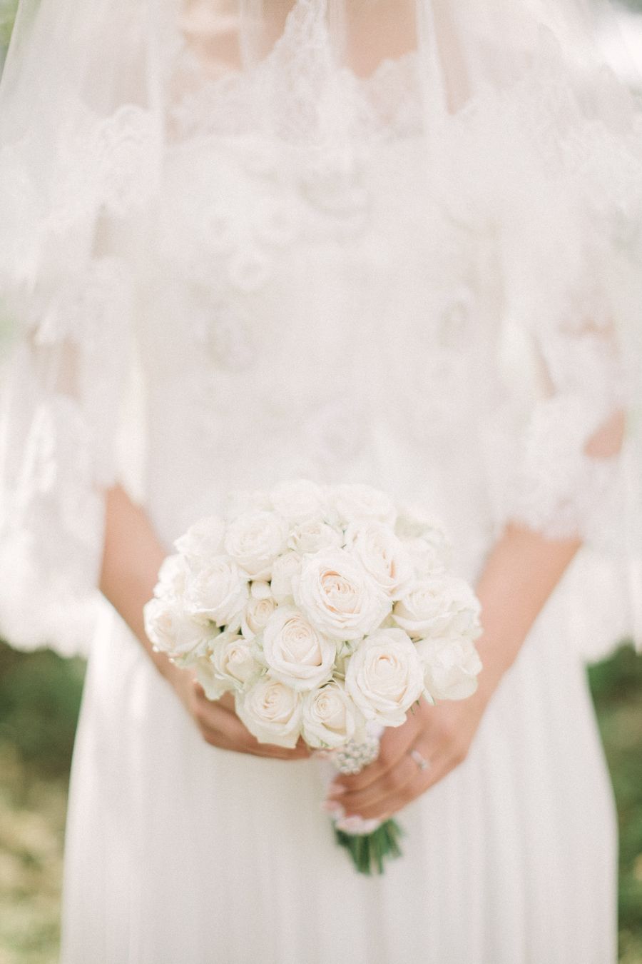 Lace bridal gown detail with white bouquet