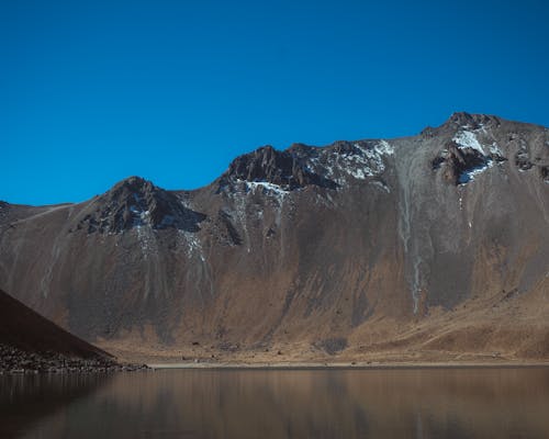 Gratis stockfoto met berg, blauwe lucht, gebied met water