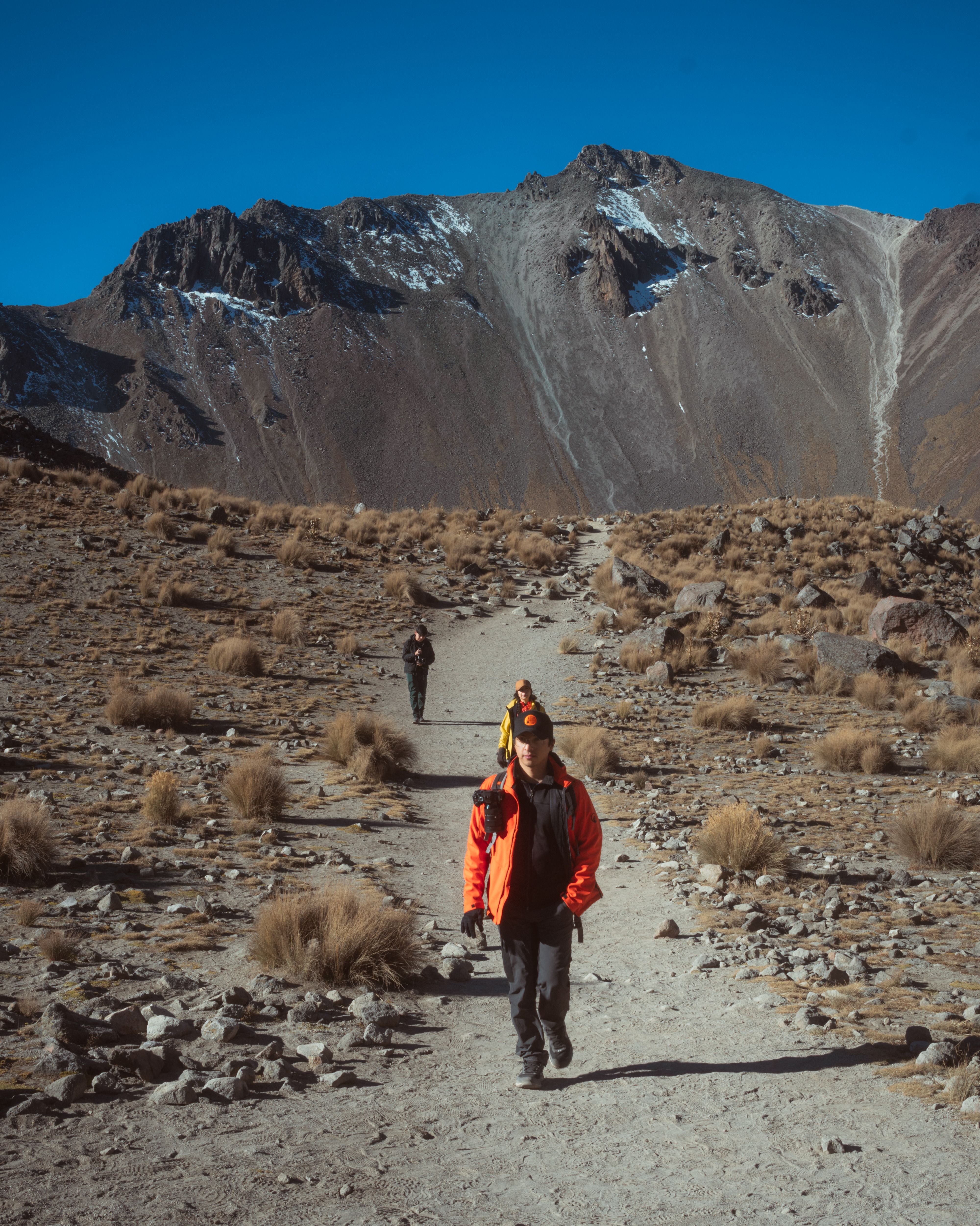 Two walkers on a rocky ridge trail — photo by Vadir Camargo on Pexels