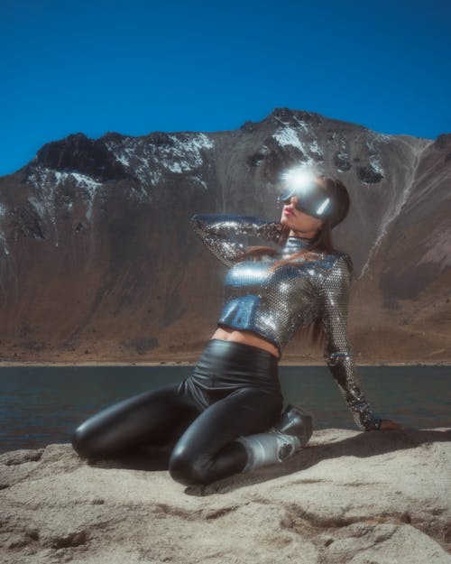 Woman in Metallic Outfit Kneeling on the Ground 