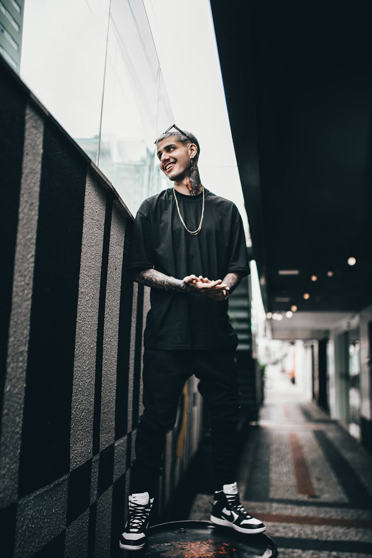 Smiling Man Standing On A Barrel Wearing Nike Dunk High Retro Shoes