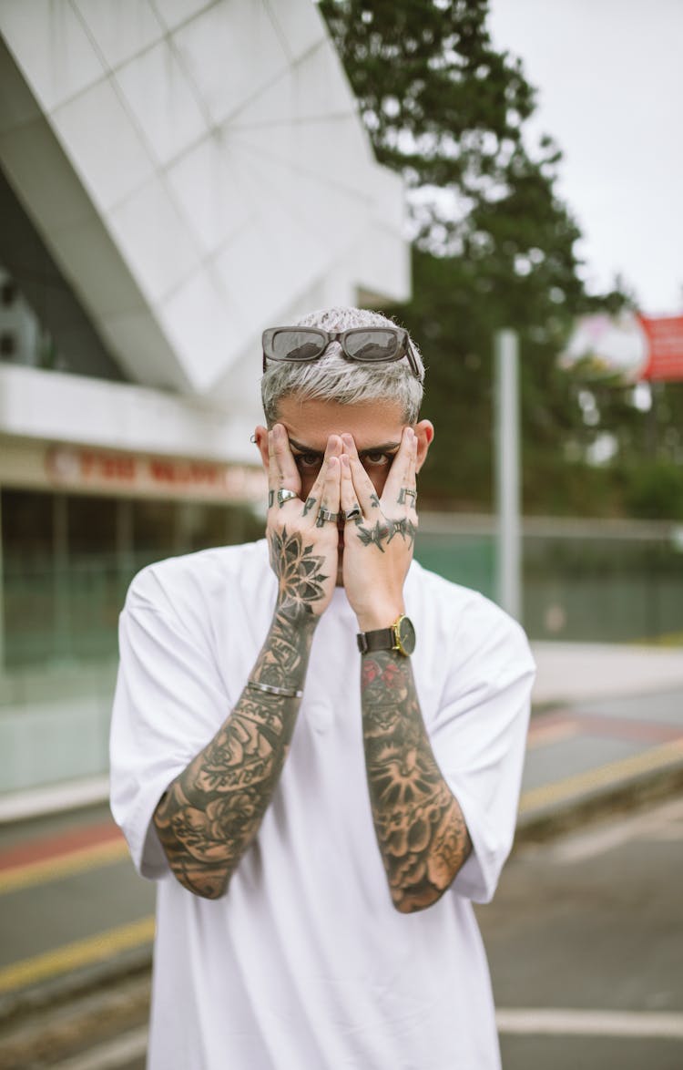 Man Covering The Face By Hands And Looking From Behind His Hands