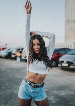 Young woman posing confidently in a parking lot, showcasing stylish fashion.
