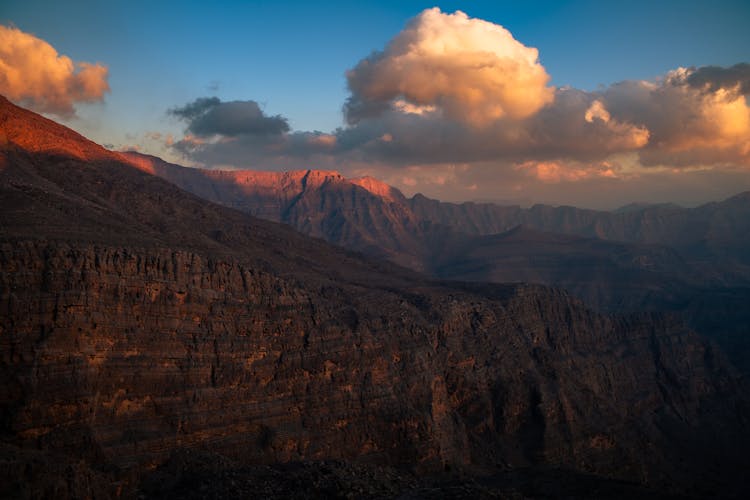 Clouds Over Barren Mountains At Sunset