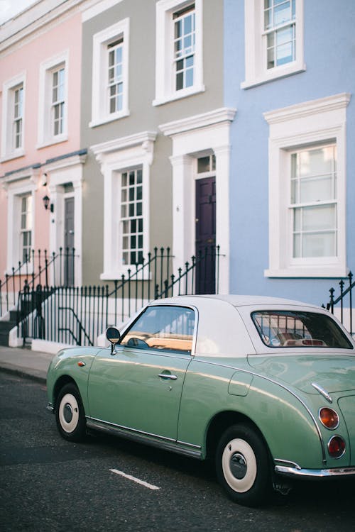 Free Green and White Coupe Parked Beside Blue Painted House Stock Photo
