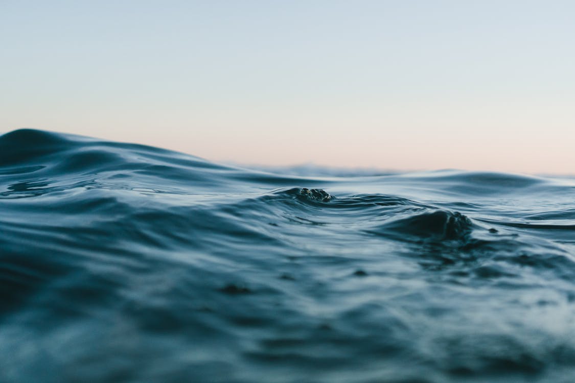 Cuerpo De Agua Bajo Cielos Azules Y Blancos