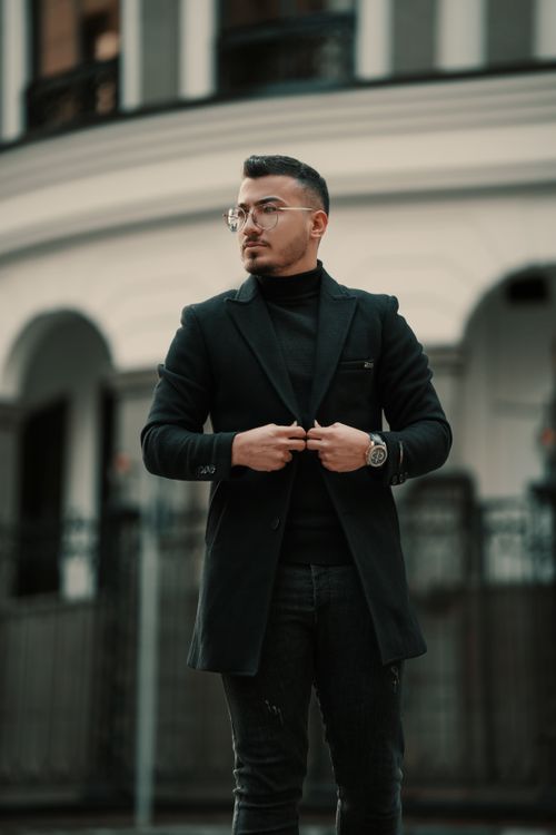 Free Elegantly dressed young man adjusting coat outdoors in Tehran, Iran. Stock Photo