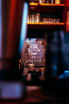Warm café interior with a humorous sign about coffee quality.
