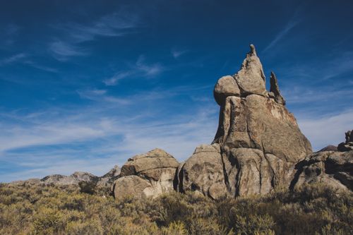 Free Scenic landscape of towering rock formations against a vivid blue sky, showcasing natural geological beauty. Stock Photo